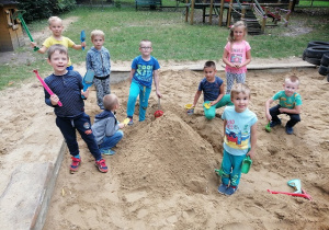 Chłopcy i Rozalia z grupy Biedronki budują zamek z piasku